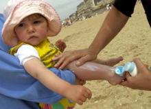 Un enfant se fait mettre de la crème solaire.