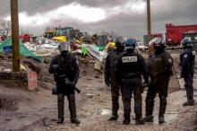 Des policiers durant le démantèlement de la "jungle" de Calais.