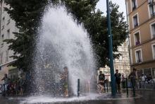 Des enfants profitent de l'ouverture "sauvage" d'une bouche d'incendie pour se rafraîchir à Pantin p