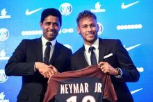 La star brésilienne Neymar (d) pose avec le maillot de son nouveau club, le PSG, à côté de Nasser Al