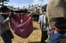 Des réfugiés rohingya porte une vieille femme dans le camp de Kutupalong, près de Ukhia, au Banglade