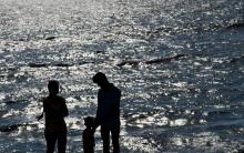 Un couple et son enfant sur une plage près de Colombo au Sri Lanka, le 13 décembre 2015