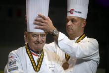 Jérôme Bocuse (droite) réajuste la toque de son père Paul Bocuse (gauche), le 30 janvier 2013, pendant les Bocuse d'Or.