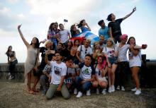 Des Youtubers cubains se prennent en photo sur le Malecon, le 27 février 2018 à La Havane