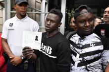 Mamoudou Gassama montre le récépissé régularisant sa situation à la sortie de la préfecture de Bobigny, mardi 29 mai 2018