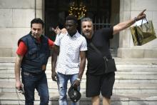 Mamoudou Gassama (c), pose avec des passants sur le péron de la mairie de Montreuil, le 28 mai 2018