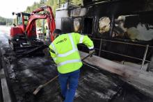 Un employé de Vinci nettoie la barrière de péage de Bandol cible d'un incendie, sur l'autoroute A50, le 18 décembre 2018