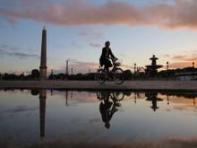 Un femme traverse la place de la Concorde à Paris à bicyclette le 13 mai 2014