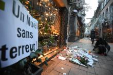 Une femme allume une bougie en hommage aux victimes de la fusillade dans une rue du centre de Strasbourg, le 13 décembre 2018