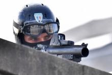 Un policier tient un lanceur de balles durant une manifestation.