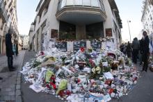 Des fleurs et des bougies sont déposées devant les locaux de Charlie Hebdo à Paris en hommage aux victimes de l'attentat, le 11 janvier 2015