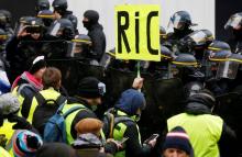 Une pancarte réclamant l'instauration d'un référendum d'initiative citoyenne (RIC) est brandie lors d'une manifestation de gilets jaunes à Paris, le 15 décembre 2018