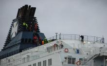 Des secouristes du Grimp (groupement de reconnaissance et d'intervention en milieux périlleux) tentent de faire descendre des migrants réfugiés en haut de la cheminée d'un ferry à Calais, le 3 mars 20