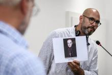 François Devaux, co-fondateur de "La Parole libérée", brandissant un portrait du cardinal Batbarin, à Genève, le 7 juin 2018