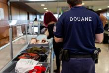 Des agents des douanes surveillent les passagers lors du contrôle de sécurité, le 27 janvier 2019 à l'aéroport Félix Eboué de Matoury, en Guyane française