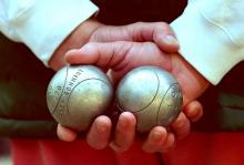 Un homme avec des boules de pétanque. 