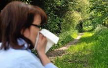 Une femme se mouche dans la forêt.