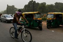 Un cycliste couvre son visage pendant une tempête de sable, le 2 mai 2018 à New Delhi, en Inde