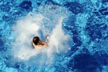 Un enfant saute dans une piscine