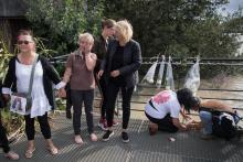 Des gens déposent des fleurs et allument des bougies sur une jetée au-dessus de la Loire le 30 juillet 2019 à Nantes à l'endroit où Steve Maia Caniço a disparu lors d'une intervention controversée des