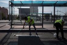 Des emplpyés municipaux nettoient les tâches de sang sur la chaussée le 1er septembre 2019 au lendemain d'agressions à Villeurbanne près de Lyon