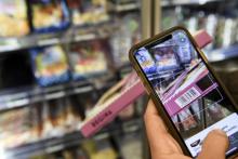 Un utilisateur de l'application Yuka scanne un aliment dans un supermarché parisien, le 25 novembre 2020