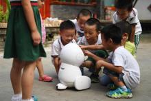 Des enfants de l'école maternelle Yiswind en Chine autour du robot Keeko, le 30 juillet 2018