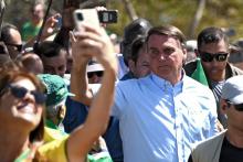 Le président du Brésil, Jair Bolsonaro (c) à la rencontre de ses partisans, le 1er mai 2022 à Brasilia