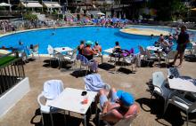 Des touristes au bord de la piscine d'un hôtel à Levante Beach à Benidorm, en Espagne, le 7 juin 2022