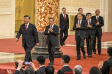 Le président chinois Xi Jinping (gauche) marche devant Li Qiang, Li Xi, Zhao Leji, Ding Xuexiang,
